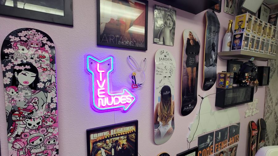Live Nudes neon sign and painted skate decks in the Pink Room