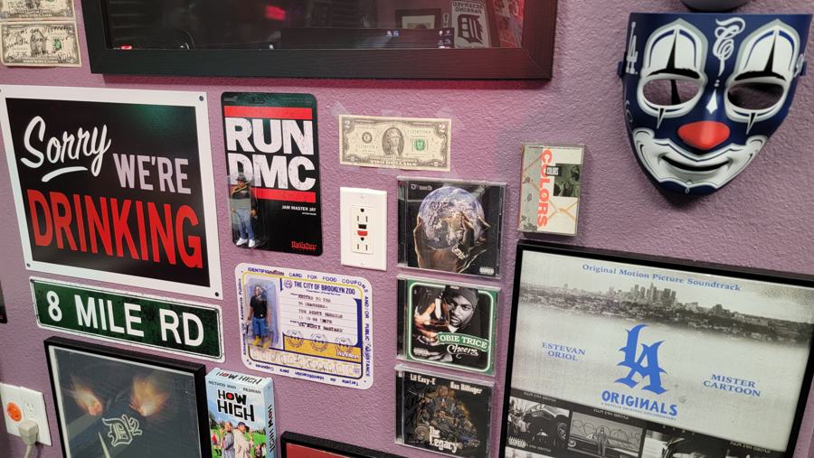 Run-DMC, 8 Mile Rd and Sorry We're Drinking signs among framed memorabilia
