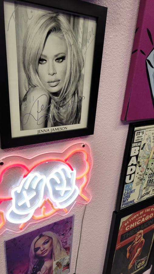 Framed portrait and neon lips sign in the Pink Room