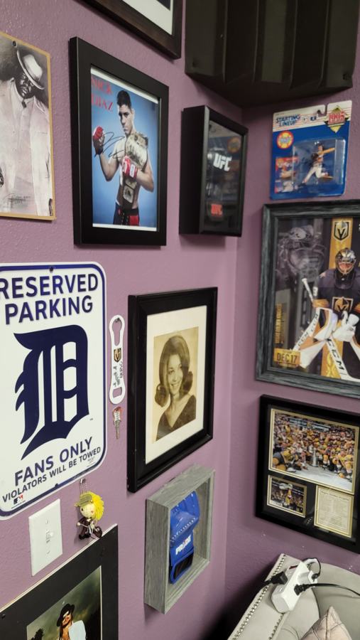 Detroit Tigers cap and Reserved Parking sign among framed photos