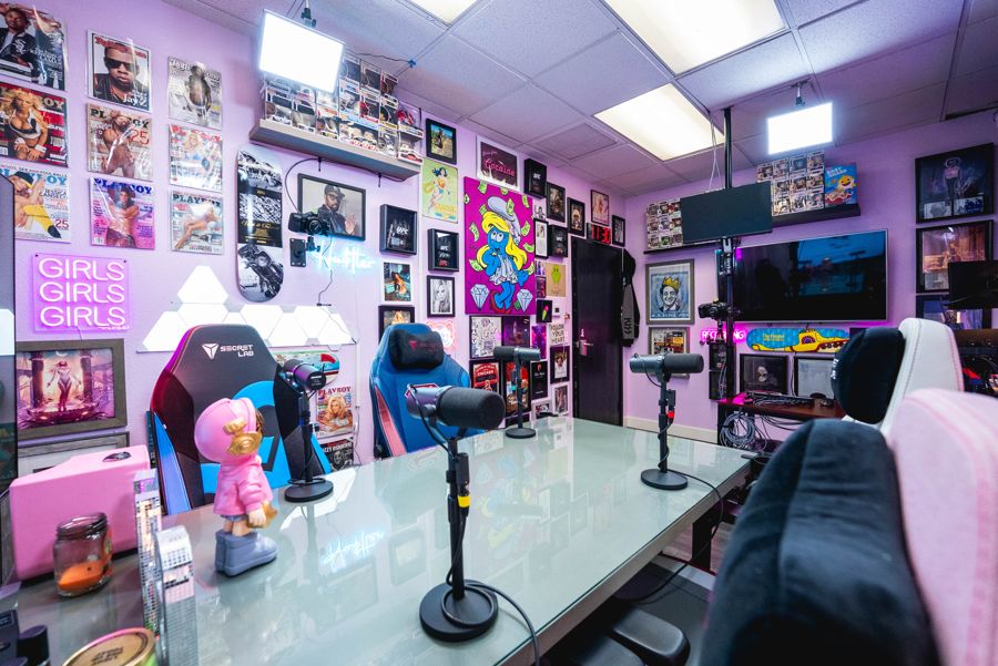 The Pink Room: pink walls covered in pop-culture art, neon signs and a glass podcast table